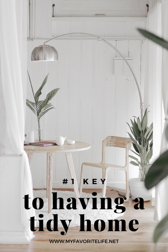 Pinterest graphic: #1 Key to having a tidy home. Breezy, ocean feel sitting area with small round table.