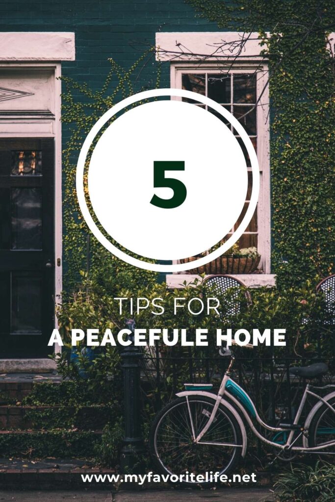 Front door and window or town home. House is covered in green vines with bike leaning against the house