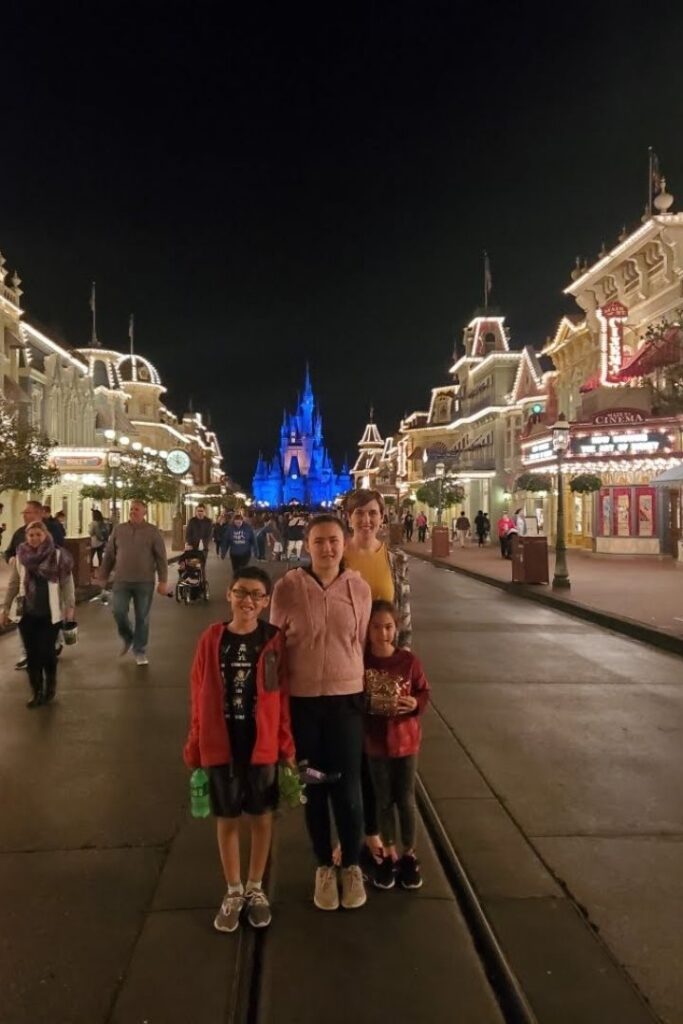 Family standing on Main Street at Disney World in the dark